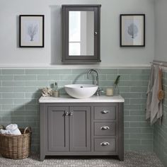 a magazine cover with a sink and mirror on the wall in front of two framed pictures