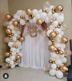 a white and gold balloon arch decorated with balloons