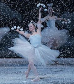 two ballerinas in blue tutus and snow falling