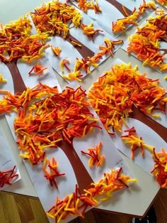 several pieces of paper with orange and yellow shredded carrots on them sitting on a table