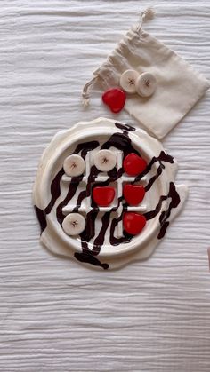 a white plate topped with chocolate and banana slices on top of a table next to a napkin