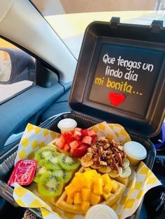 a tray filled with fruit sitting on top of a car seat