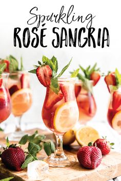 sparkling rose sangria with strawberries and lemons on a cutting board next to glasses