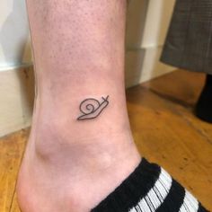 a small snail tattoo on the ankle