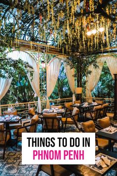 an indoor dining area with tables, chairs and chandelier hanging from the ceiling