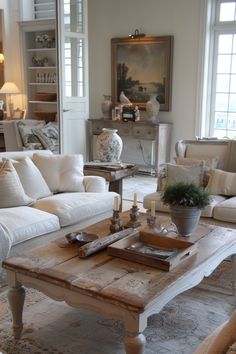 a living room filled with white furniture and lots of pillows on top of it's couches