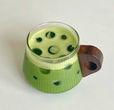 a green drink in a glass on a white table