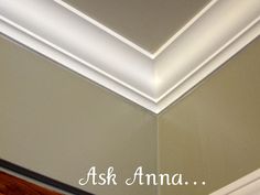 the corner of a room with a light above it and an ask ama sign below