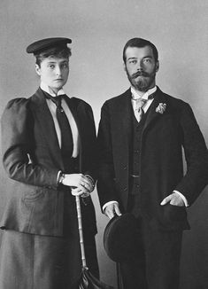 an old black and white photo of two men dressed in formal wear, one holding a cane