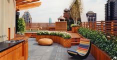 an outdoor patio with wooden planters, benches and potted plants on the roof