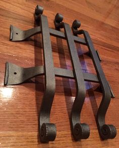 two metal brackets sitting on top of a wooden table