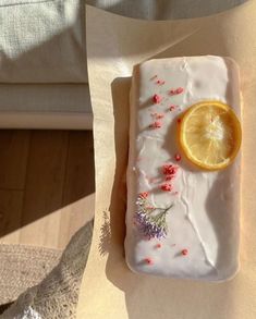 a piece of cake sitting on top of a table next to a slice of lemon