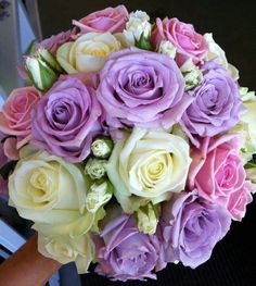 a bridal bouquet with purple and white roses