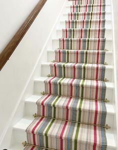 a striped stair runner on the bottom of a set of stairs