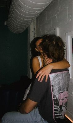 two people embracing each other in a room