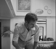 a man is eating something while standing in front of a table with a cake on it