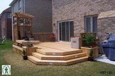 a wooden deck in front of a brick building