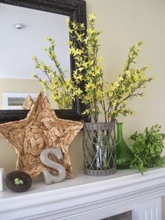 a fireplace mantel with yellow flowers and decorative items on it, including a star