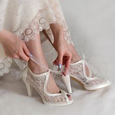 a woman is tying her wedding shoes