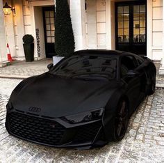 a black sports car parked in front of a building