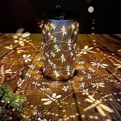 a lit up lantern sitting on top of a wooden table