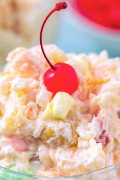 a close up of a bowl of food with a cherry on the top and other items in the background