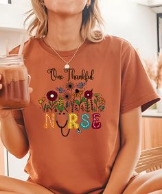 This 'One Thankful Nurse' t-shirt features a vibrant fall-themed design with wildflowers, bats, and a stethoscope, perfect for cozy autumn days. Available in warm earthy tones, this Comfort Colors shirt blends soft, cottagecore aesthetics with a heartfelt message. Ideal for nurses who love nature and the beauty of fall, it's a thoughtful and stylish way to show appreciation and celebrate the season. Product Features - Printed with ink - Unisex T-Shirt - Comfort Colors 1717 - Relaxed fit - 7/8″ double-needle topstitched collar - Double-needle armhole, sleeve, and bottom hems *Fabrication - Made with medium fabric (6.1 oz/yd² (206.8 g/m consisting of high quality, 100% ring-spun US cotton for long-lasting comfort.  - pre-shrunk cotton for size retention *Care Instructions - Turn inside out a Soft Cottagecore, Gifts For Nurse, Autumn Days, Comfort Colors Shirt, Cozy Autumn, Nurse Shirt, Nursing Tshirts, Fall Shirt, Comfort Colors Tee