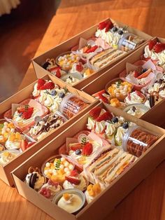 three boxes filled with different types of food on top of a wooden table next to each other