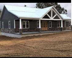 a house that is in the middle of some dirt and has two windows on it