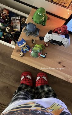 a person with their feet up on a table next to video game controllers and toys