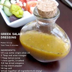 a bottle filled with liquid sitting on top of a table next to a bowl of vegetables