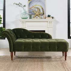 a green couch sitting in front of a fire place next to a painting on the wall