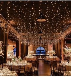 an indoor venue with tables and chairs covered in lights