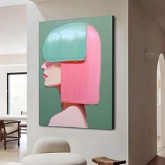 a painting on the wall in a living room with white chairs and a green table