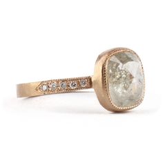 a close up of a ring with a stone in the middle and diamonds on it