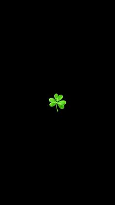 a four leaf clover is shown in the middle of a dark black background that appears to be lit up