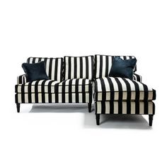 a black and white striped couch sitting next to a blue pillow on top of it