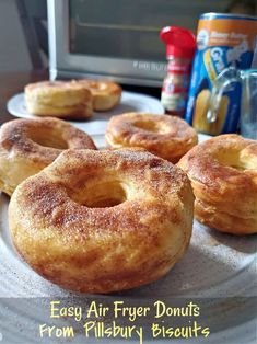 several doughnuts are on a plate near a toaster