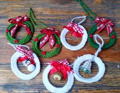 christmas ornaments are arranged on a wooden surface with ribbons and bells hanging from the top