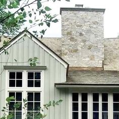 a white house with two windows and a brick chimney