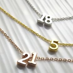 Dainty number necklace. Add as many numbers as you like. Perfect necklace for that 18th or 21st birthday. Material: plated over brass, lead/nickel free. Numbers are 7mm in size, please see model picture for size reference. Care: This necklace is delicate please handle with care. Avoid, water pools perfumes, beaches and liquids. Keep in a cool dry place, air tight container or jewelry box when not in use for longer lasting. Plated jewelry is a great way to accessorize in an affordable way and if Double Numbers, Sweet 16 Birthday Gifts, Year Necklace, Flower Girl Jewelry, Lucky Jewelry, Idea Birthday, Number Necklace, Wedding Bridesmaid Jewelry, Birthday Jewelry