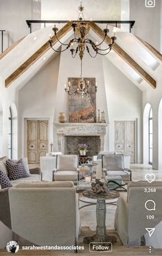 a living room filled with lots of furniture and a chandelier hanging from the ceiling