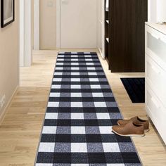 a black and white checkered rug is on the floor next to a pair of shoes