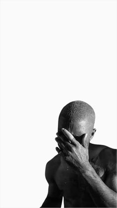 a black and white photo of a man holding his face to his chest with both hands