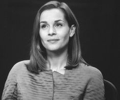 a black and white photo of a woman with shoulder length hair wearing a gray sweater