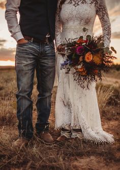 a bride and groom standing in the middle of a field