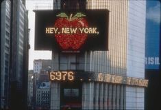 an apple sign on the side of a tall building in new york city, ny