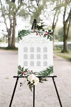 a wedding seating sign with greenery and flowers