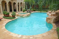 a swimming pool surrounded by landscaping and plants