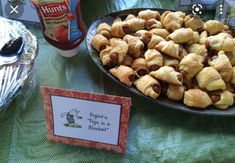 there is a plate of pigs in a blanket on the table next to other items